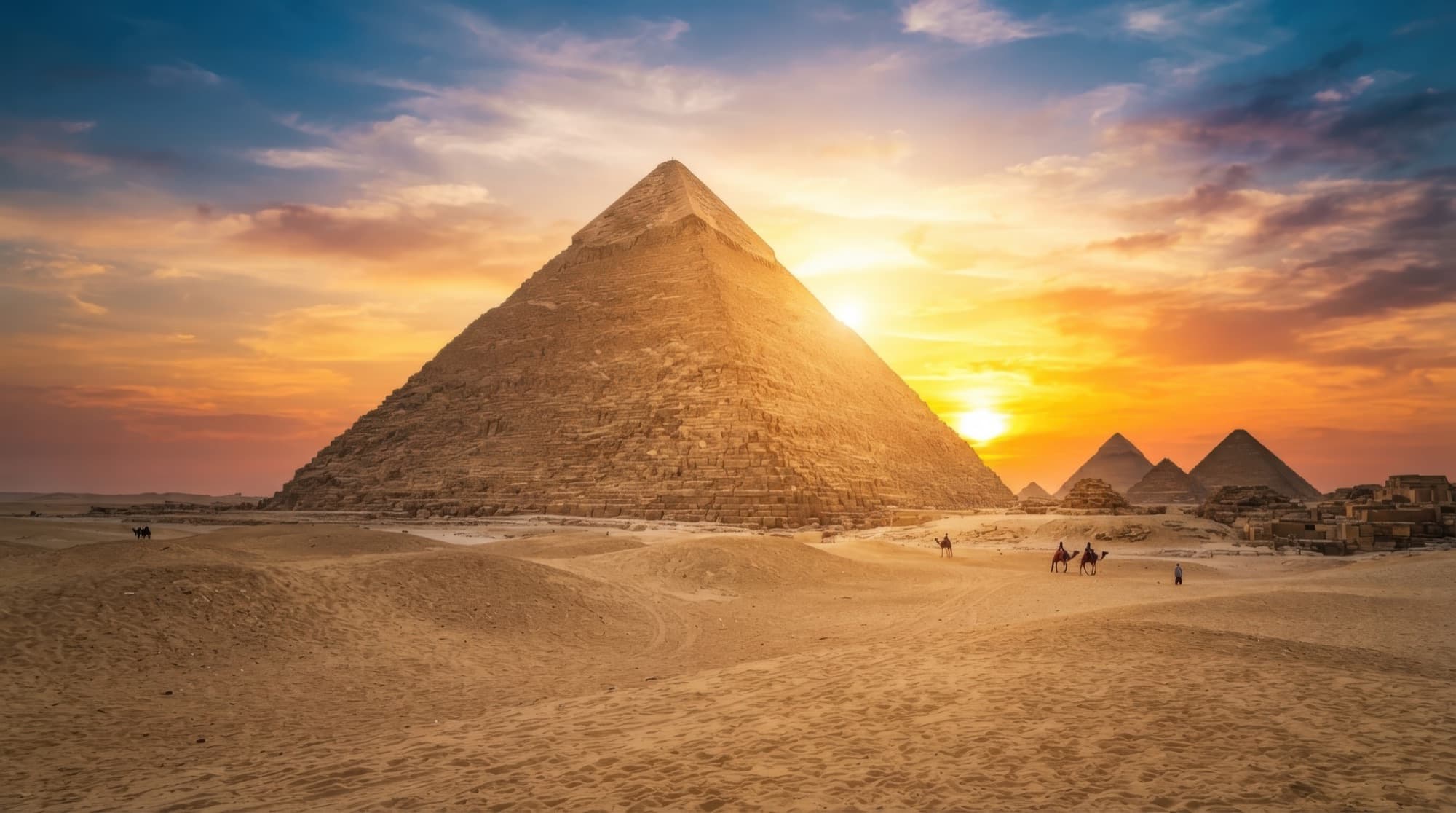 The Great Pyramid of Giza at sunset, camels crossing the sand